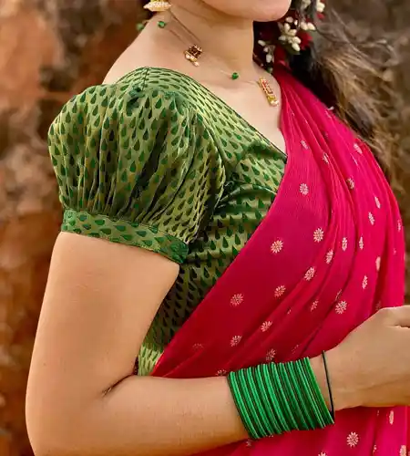 short sleeve green brocade puff blouse paired with red saree