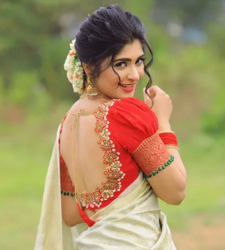 red color puff sleeve blouse paired with white silk saree