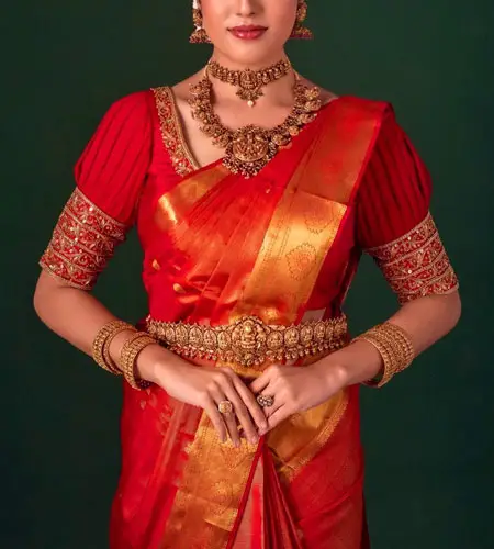 red pleated puff blouse paired with red silk saree.