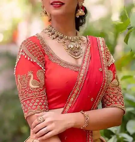 elbow sleeve red blouse with peacock embroidery paired with soft silk saree