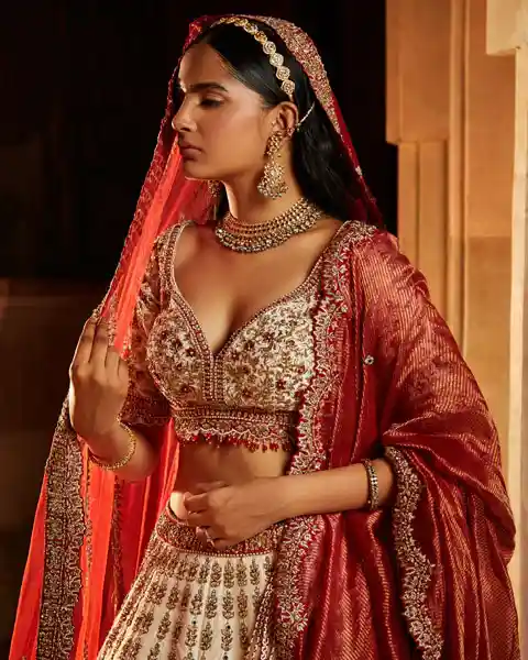 off-white bridal lehenga blouse with gold and maroon thread work design